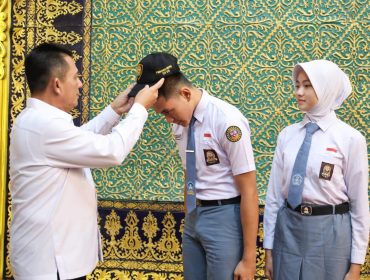 Gubenrur Kepri Ansar Ahmad memasangkan topi Calon Paskibraka kepada Muhammad Salman Farisi dan Raudah Mabrura, perwakilan Kepri Calon Pasukan Pengibar Bendera Pusaka (Paskibraka) Nasional Tahun 2026 di Gedung Daerah Tanjungpinang, Senin (13/7/2026). 