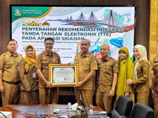 Sekretaris Diskominfo Kepri, James Simon Pattikawa menyerahkan Piagam Pengesahan Integrasi TTE Aplikasi SIGAJIAN kepada Kepala Bidang Perbendaharaan dan Pengelolaan Kas Daerah BKAD Kepri I Gede Sukanta, Selasa (4/8/2026).