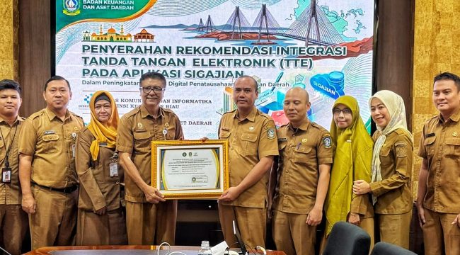 Sekretaris Diskominfo Kepri, James Simon Pattikawa menyerahkan Piagam Pengesahan Integrasi TTE Aplikasi SIGAJIAN kepada Kepala Bidang Perbendaharaan dan Pengelolaan Kas Daerah BKAD Kepri I Gede Sukanta, Selasa (4/8/2026).