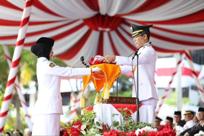 
					Wali Kota Batam, Amsakar Achmad, menyerahkan Bendera Merah Putih saat Upacara HUT ke-81 RI di Dataran Engku Putri, Batamcentre, Senin (17/8/2026). 