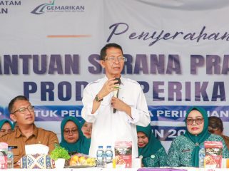 Wali Kota Batam, Amsakar Achmad, didampingi Ketua TP-PKK Batam, Erlita Amsakar, dan Kepala Dinas Perikanan Kota Batam, Yudi Atmajianto, menyampaikan sambutan saat penyerahan bantuan sarana dan prasarana kepada kelompok pengolah dan pemasaran hasil perikanan di Sagulung, Senin (14/9/2026). 