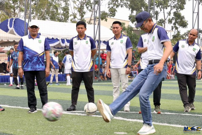 
					Wali Kota Batam, Amsakar Achmad, menendang bola saat membuka Kejuaraan Minisoccer dalam rangka HUT ke-26 DPRD Kota Batam di Lapangan Gama Minisoccer, Bengkong, Sabtu (17/10/2026). 